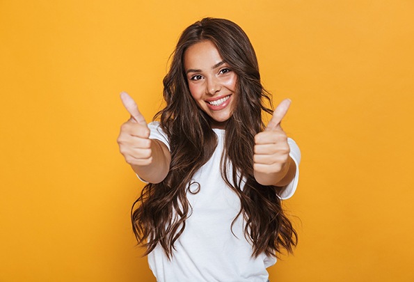 Smiling woman giving thumbs up