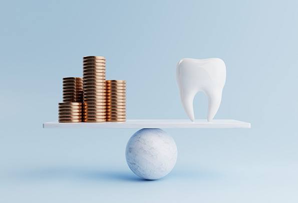 A large model tooth and stacks of coins on a balance beam