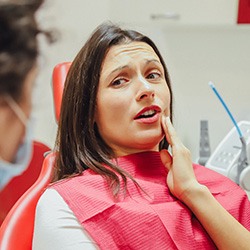 A pained woman talking to her dentist about root canal treatment