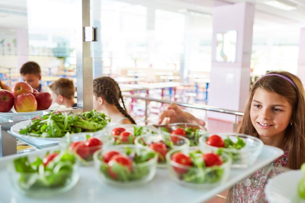 A little girl in the lunch line at a her school's cafeteria