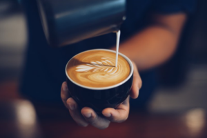 Close up of someone pouring a latte with foam art